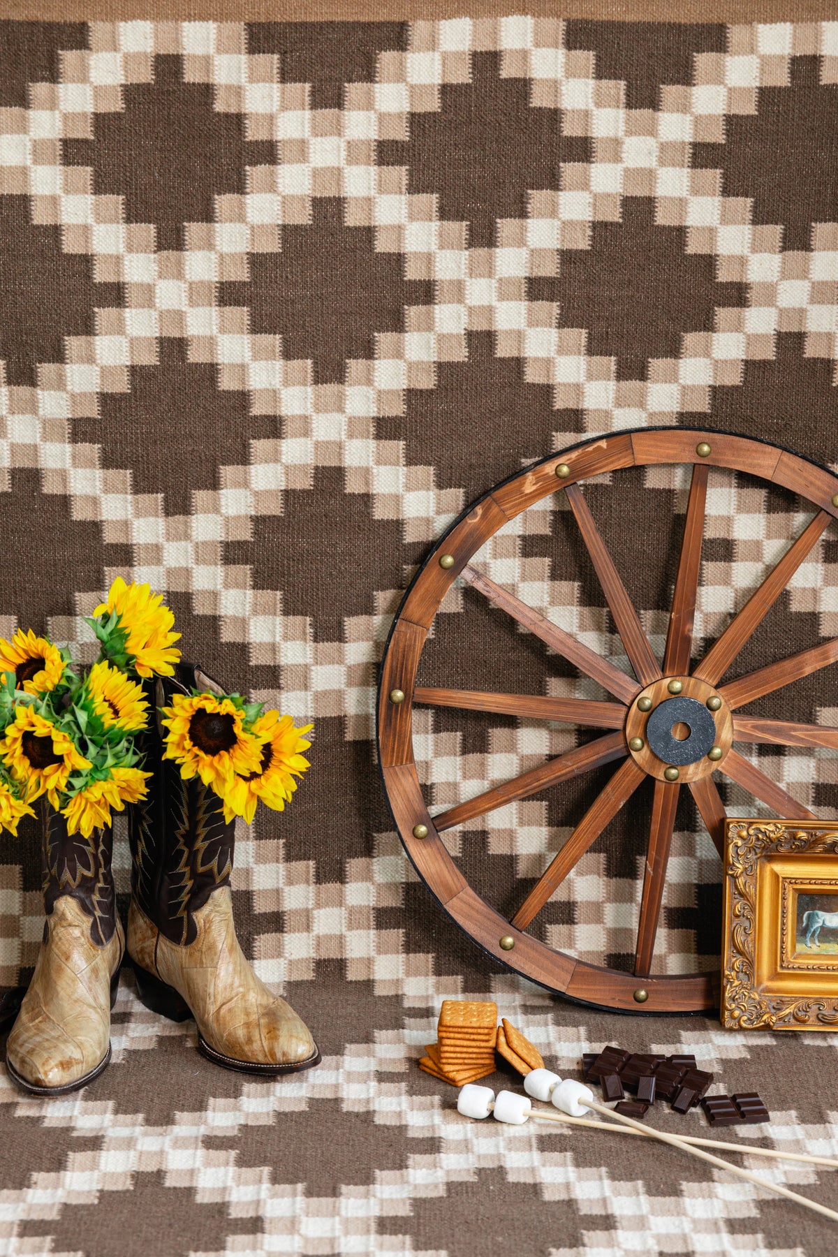 Brown and ivory Southwestern flatweave rug styled with Western boots, wagon wheel and rustic decor