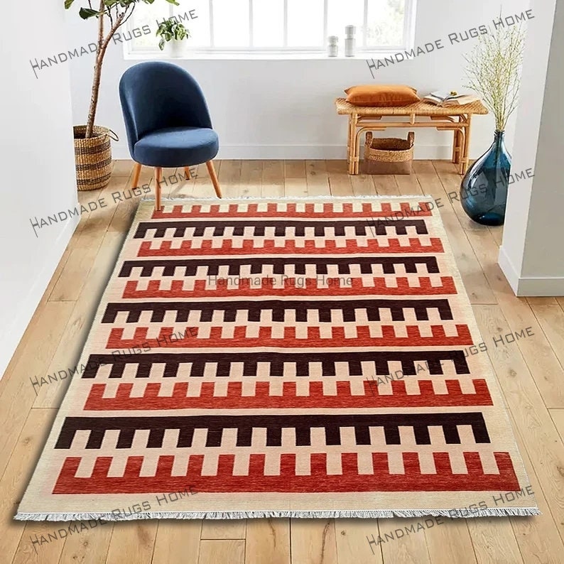 Handmade geometric area rug with bold red and black patterns.