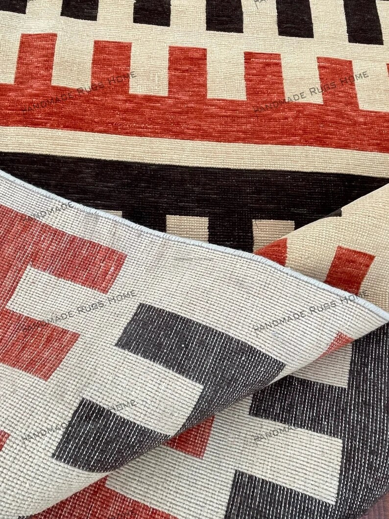 Elegant handwoven rug with red and black stripes, perfect for a minimalist décor.