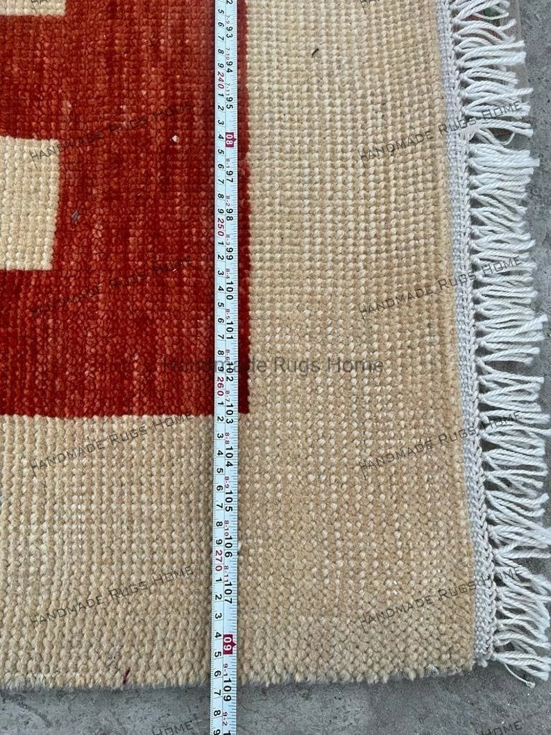 Handcrafted modern rug with striking red and brown geometric patterns.