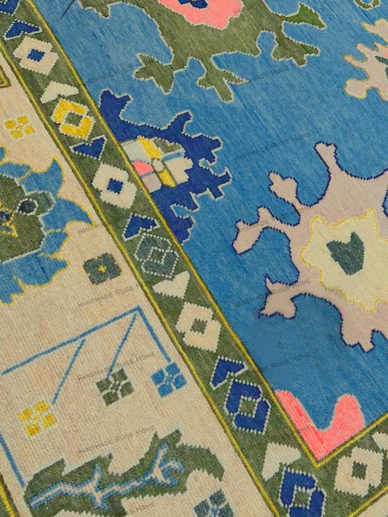 Vibrant bohemian area rug featuring blue, pink, green, and cream abstract botanical motifs.