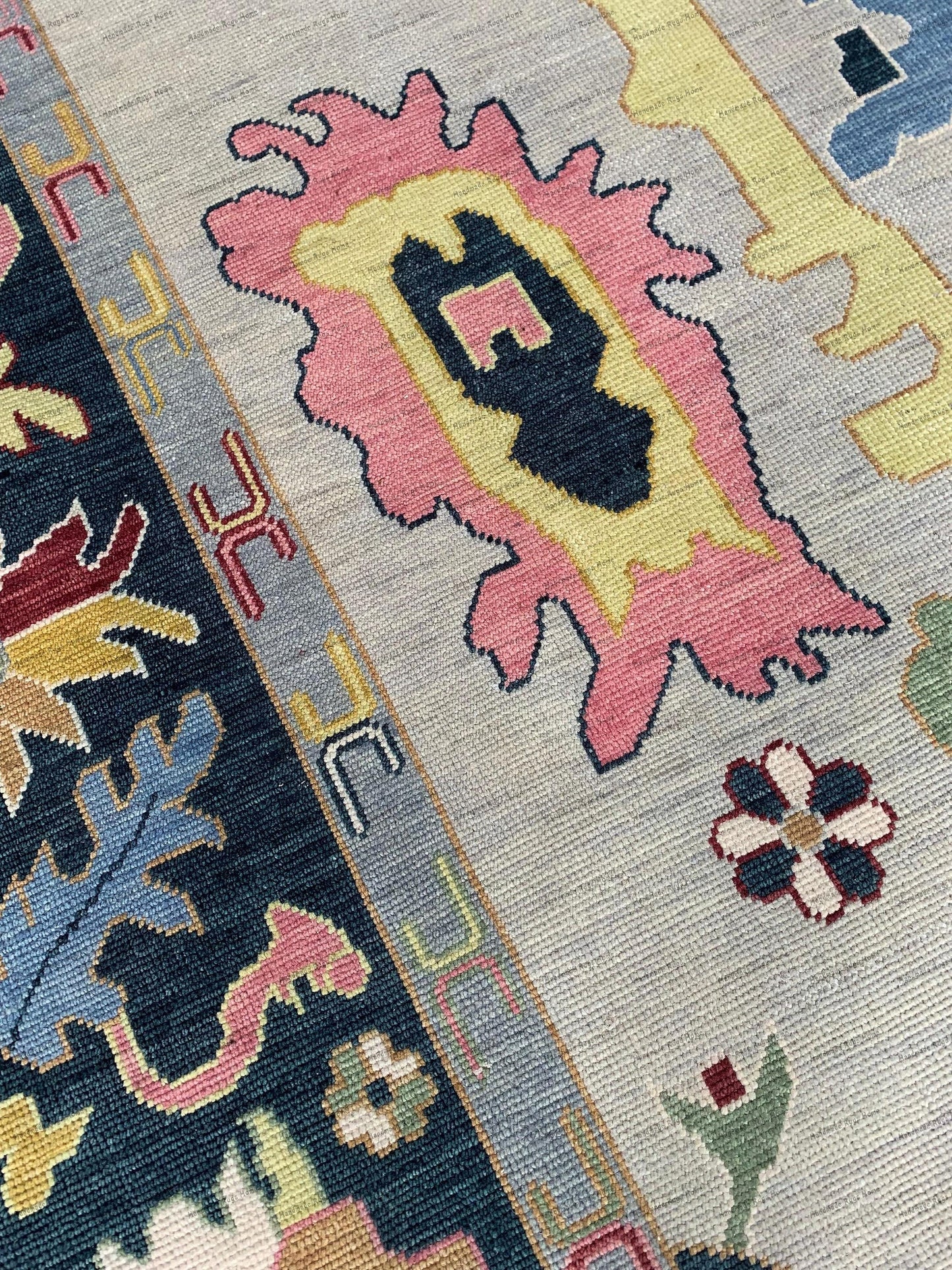 The image features a colorful Turkish Oushak rug with intricate designs. Sunlight enhances its plush wool texture against a polished wooden floor. Minimalist decor and neutral furniture frame the rug, highlighting its elegant and timeless charm.