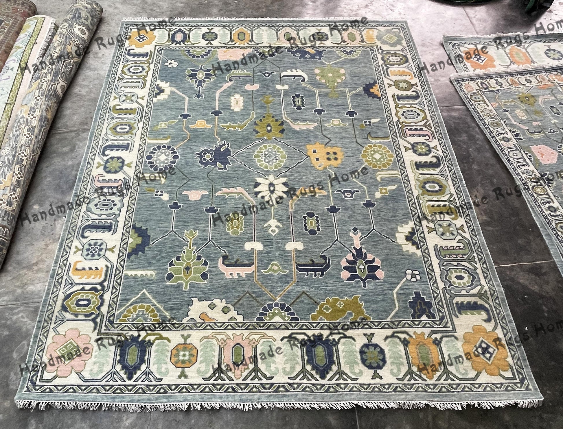 Blue and beige hand-knotted Oushak rug with floral details.