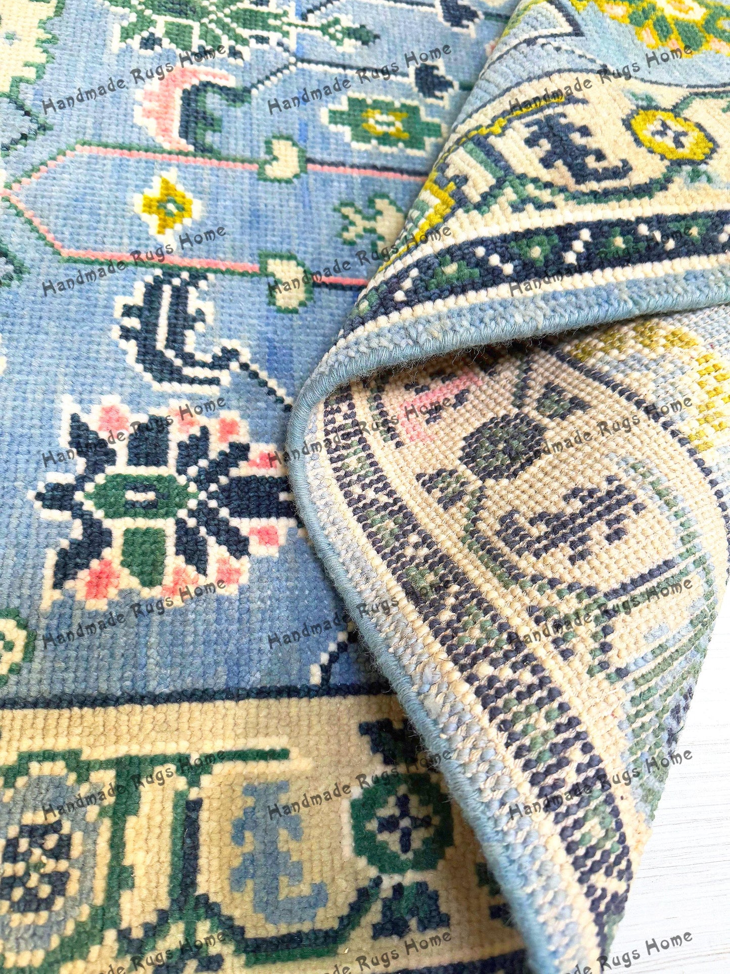 Hand-knotted blue Oushak rug with intricate floral patterns.