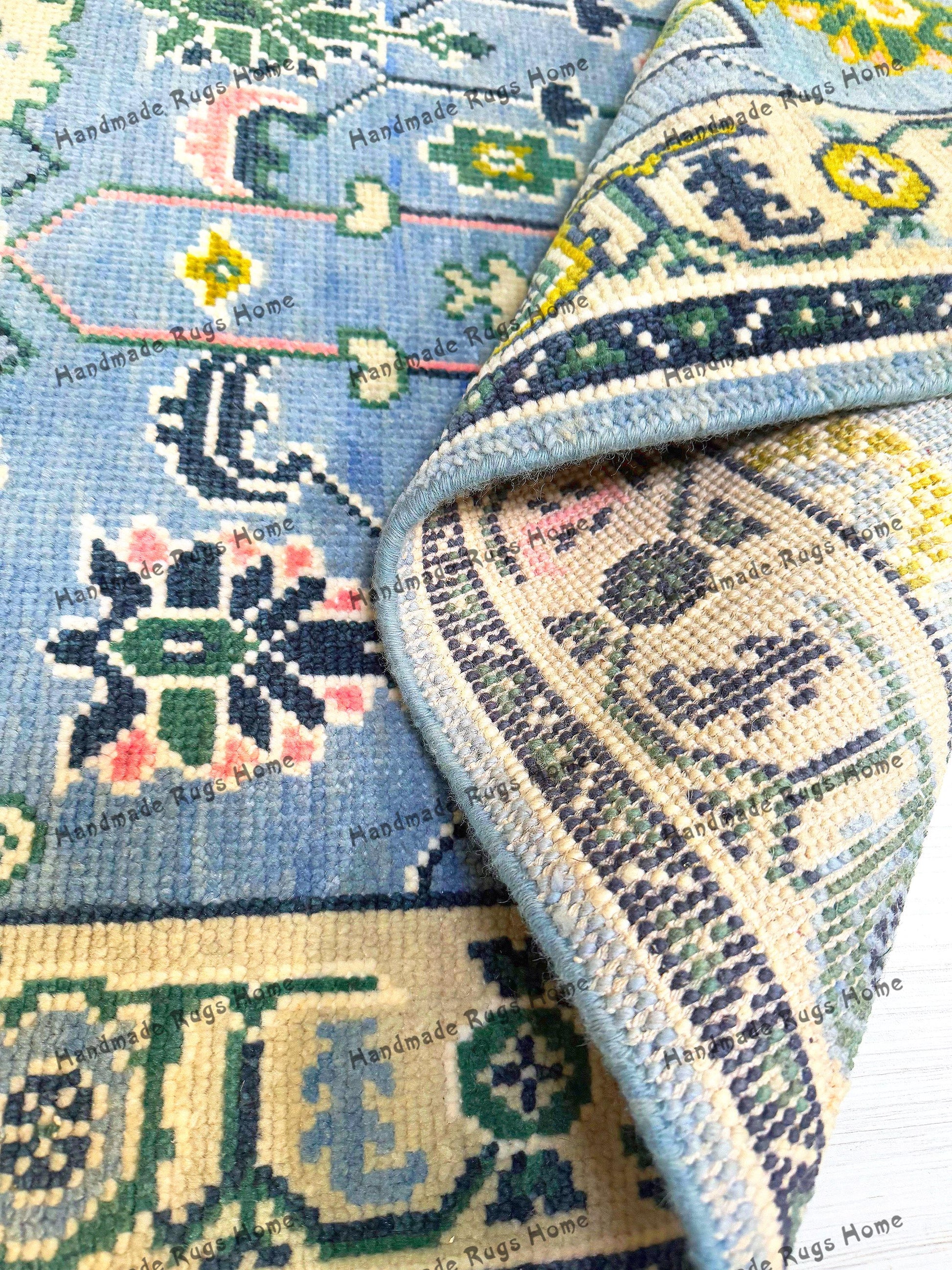 Hand-knotted blue Oushak rug with intricate floral patterns.