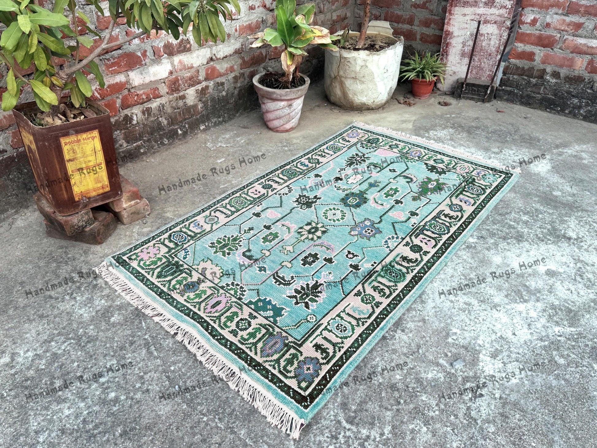 Handwoven turquoise Oushak rug with floral and geometric patterns, perfect for boho or vintage decor.