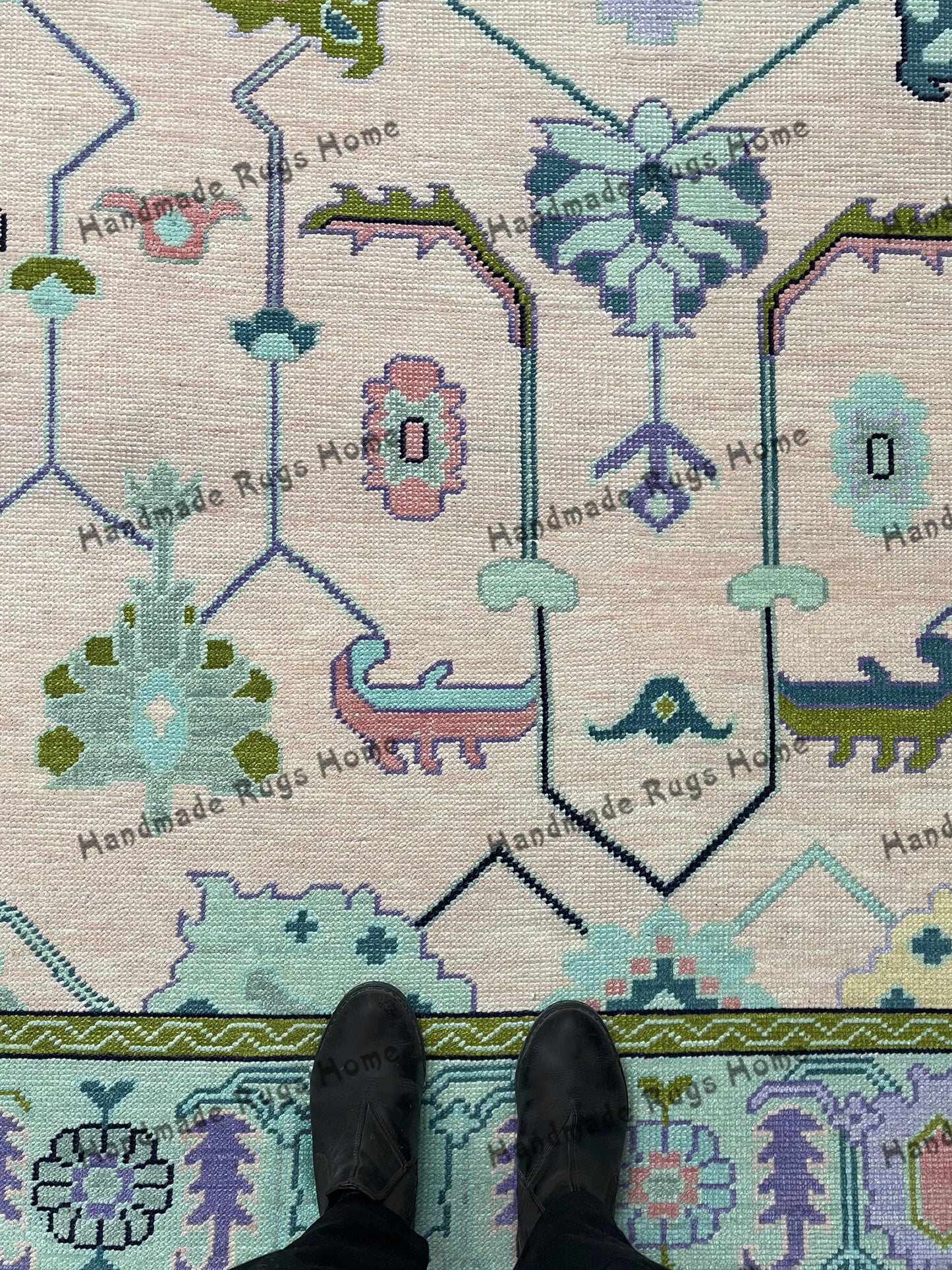 Vintage-inspired geometric area rug in green and pink hues.