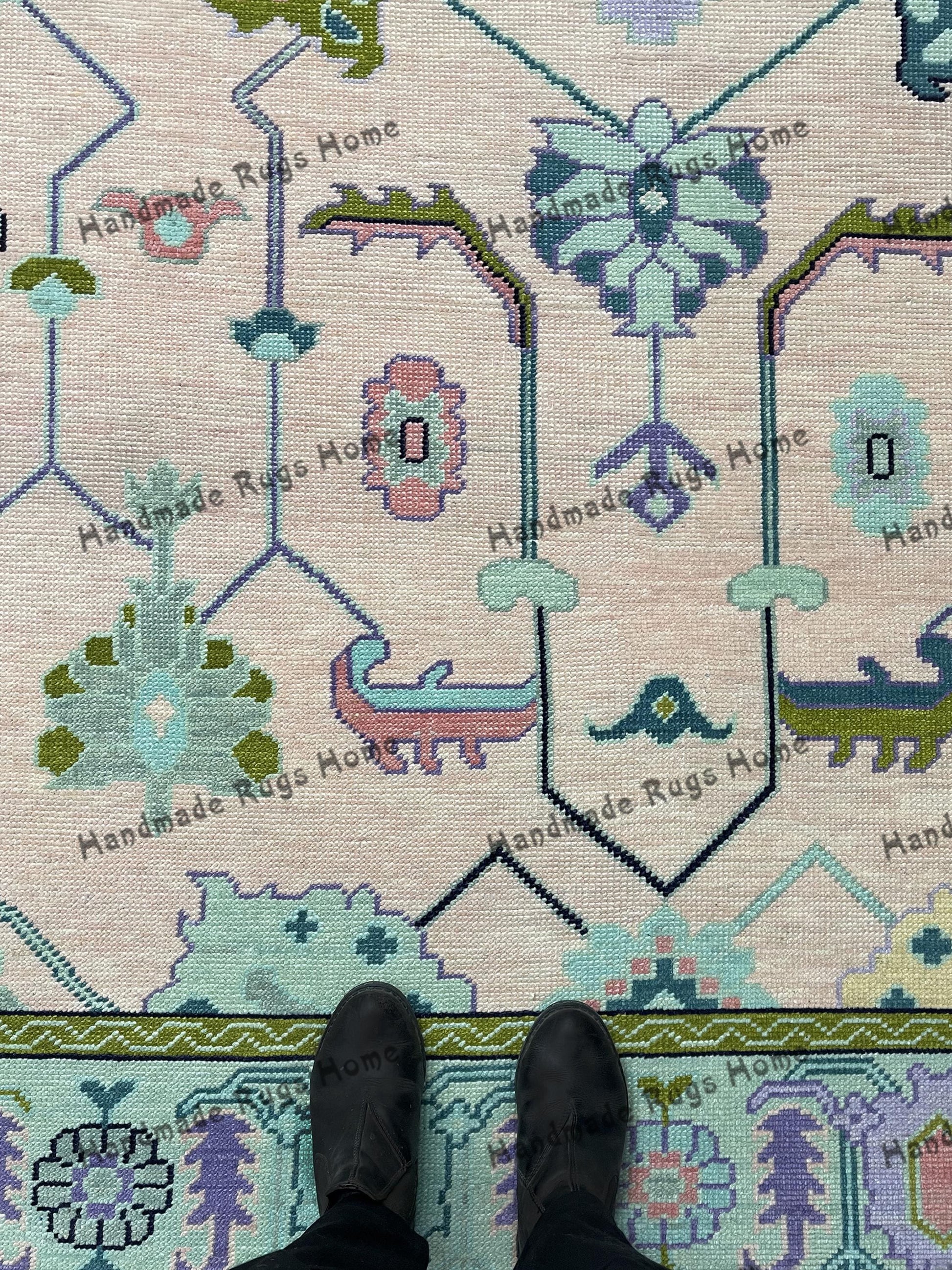 Vintage-inspired geometric area rug in green and pink hues.
