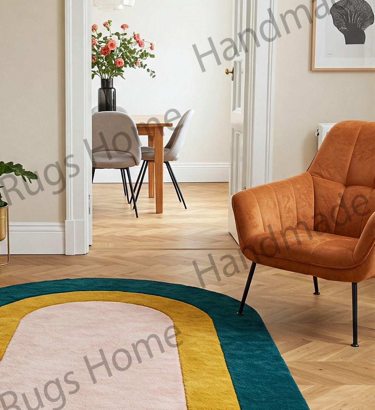 Modern oval area rug featuring a teal outer border, mustard frame, and pink center.