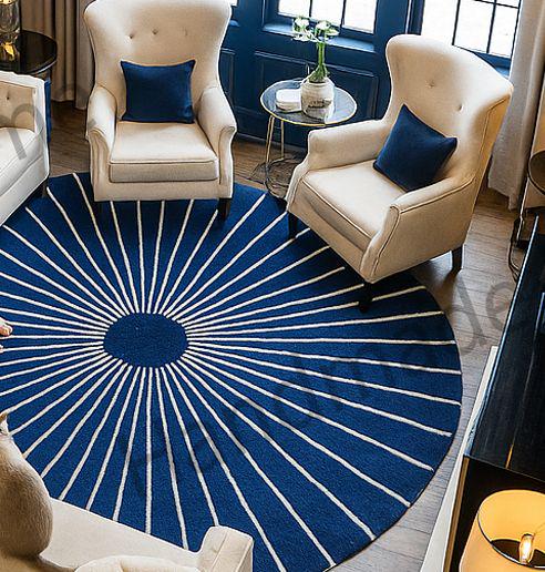 Overhead view of a blue and white geometric hand-tufted wool rug with cream sofas