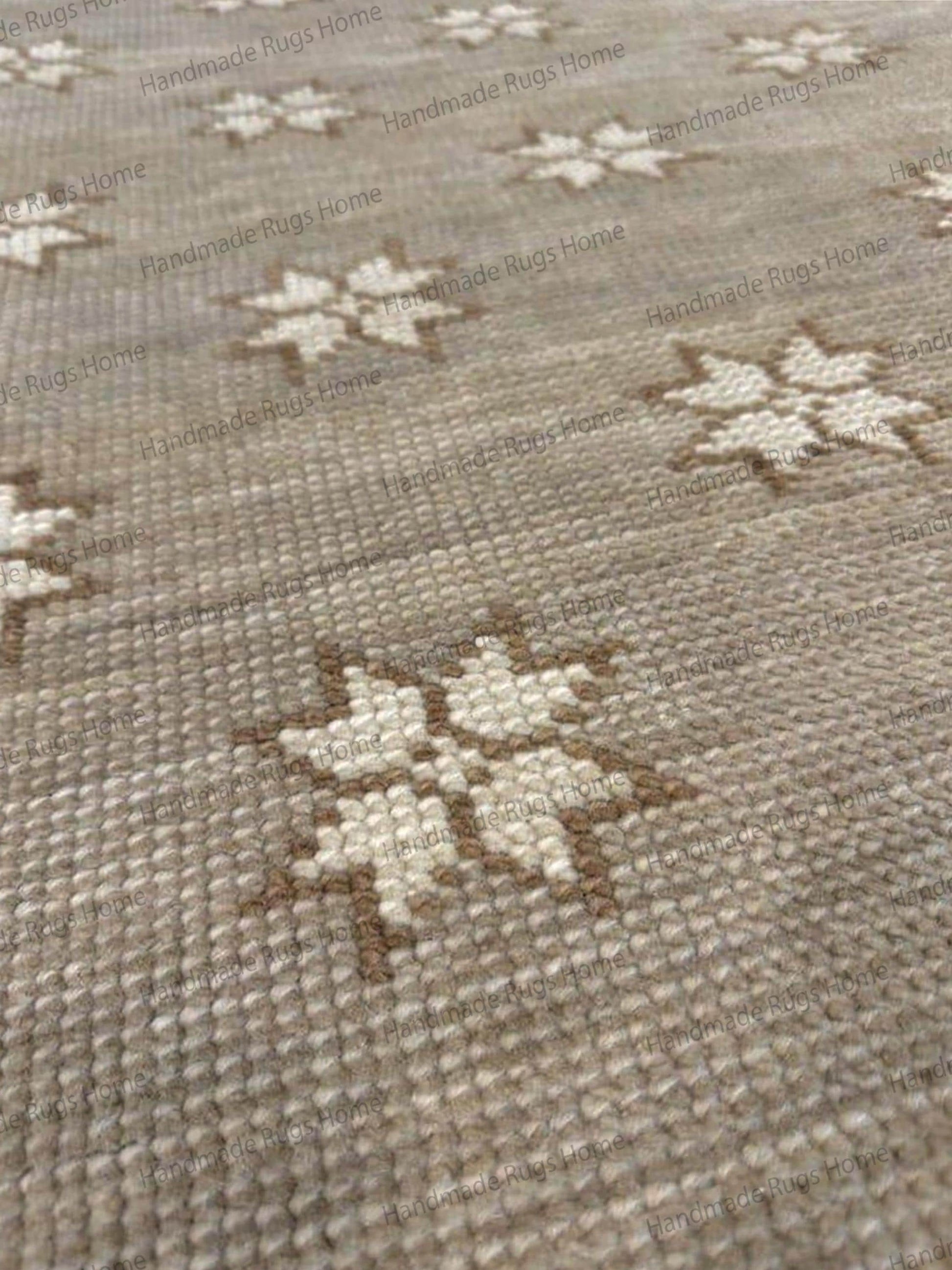 Hand-knotted wool rug in beige with a repeating cream and tan star pattern.