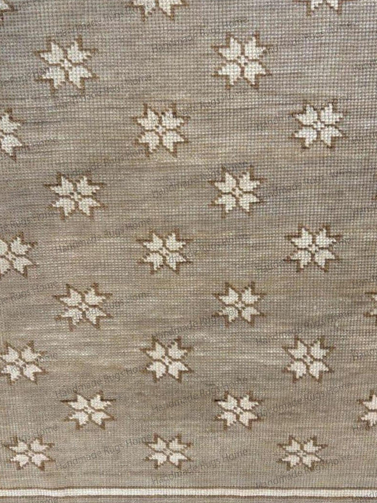 Close-up of a neutral beige area rug featuring a subtle geometric star motif.