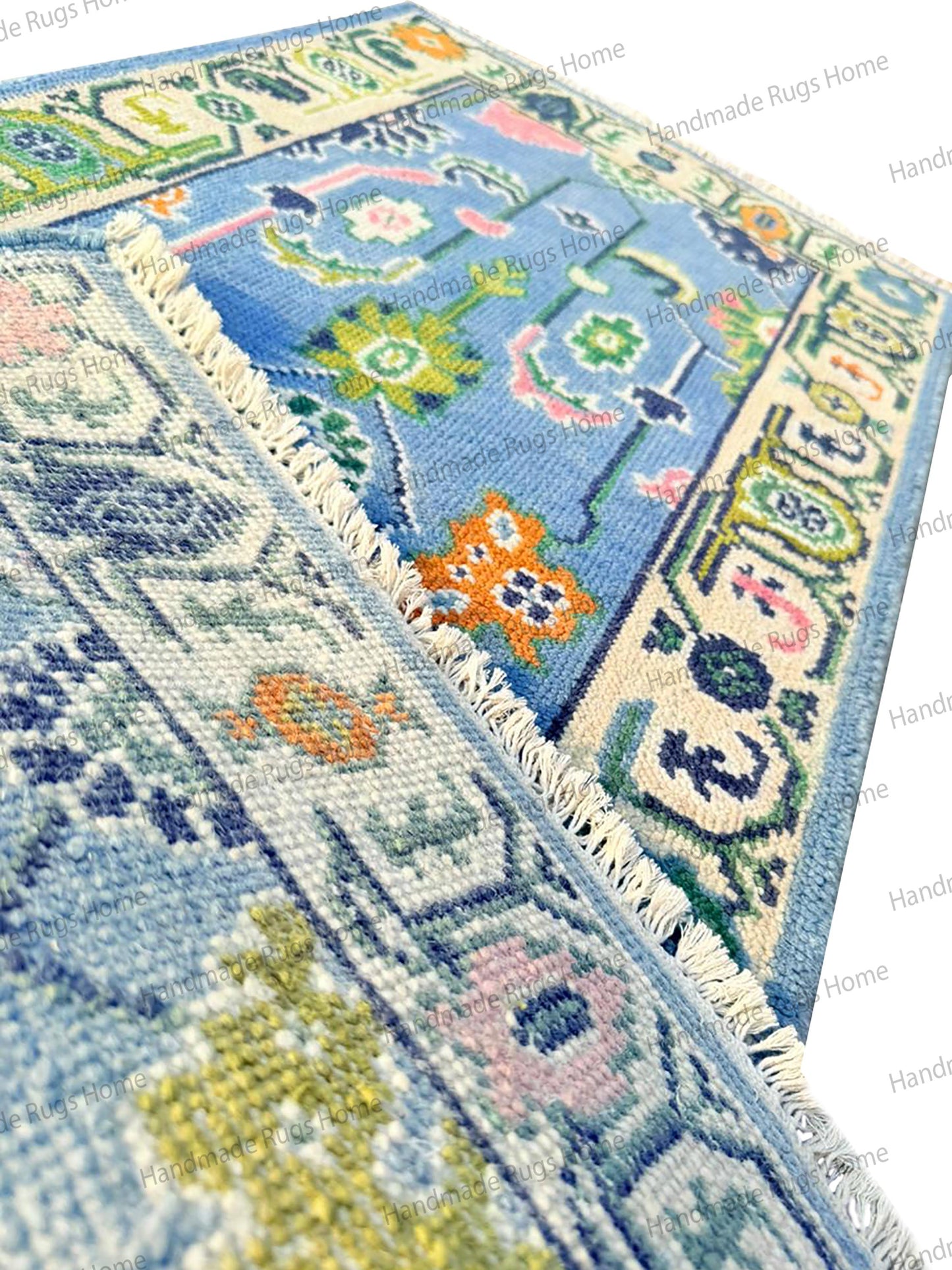 Premium wool rectangular rug in light blue, featuring intricate pink and dark blue botanical detailing. Perfect for a cozy, stylish home.