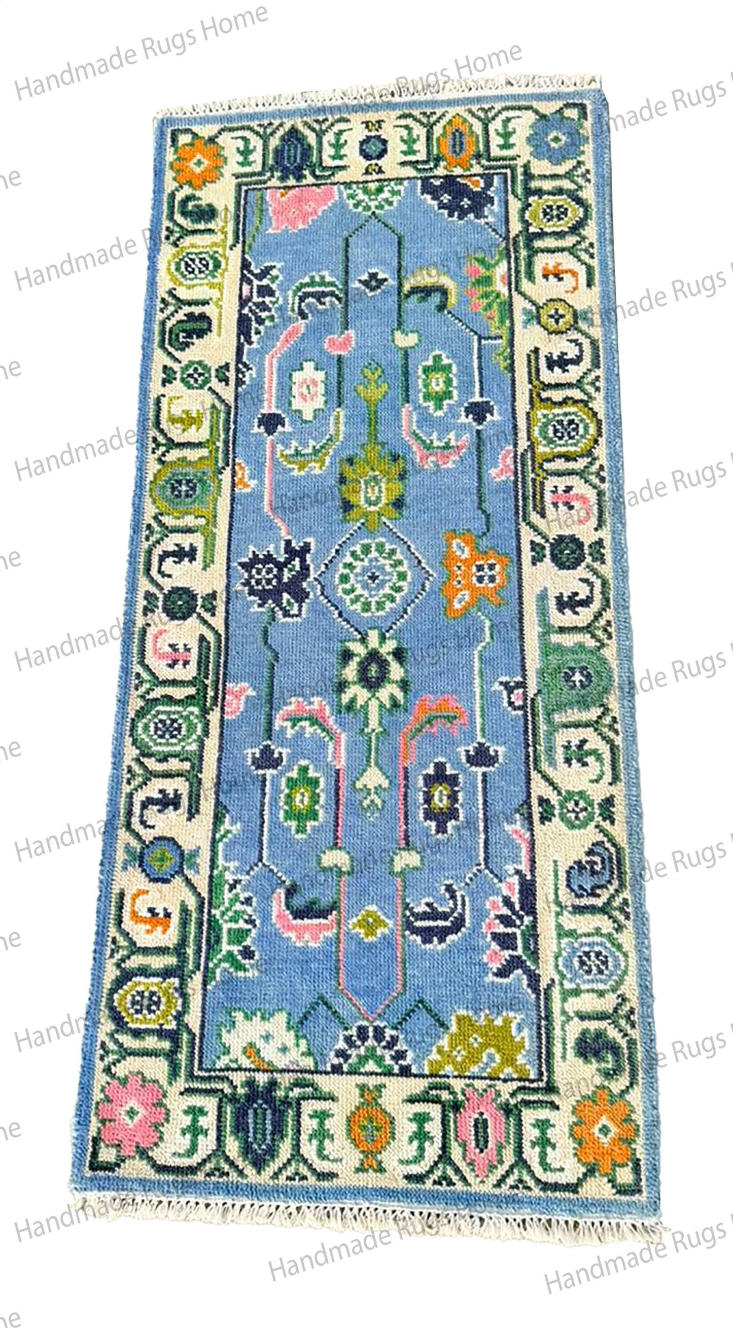 Hand-tufted light blue and multi-tone floor covering. Durable textile showcasing a classic weave and modern pastel color palette.