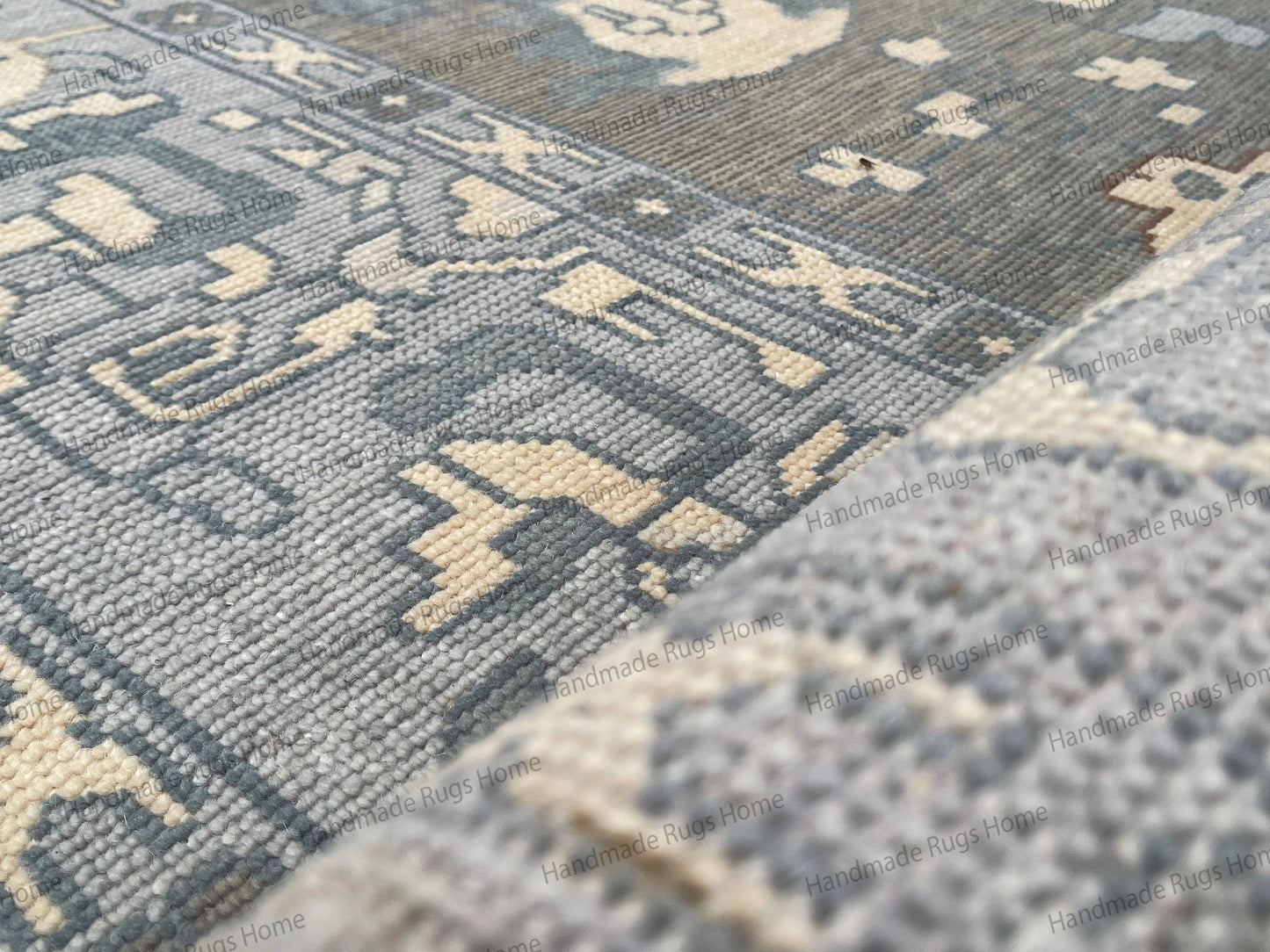 Hand knotted wool area rug in grey and blue tones with ivory accents