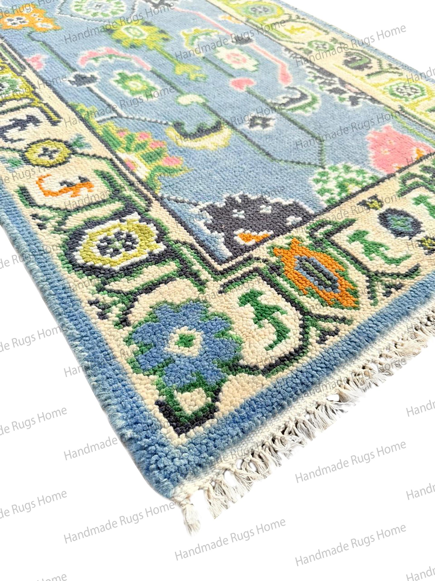 Unique blue and pink area rug. Custom size hand-knotted wool carpet with geometric border, photographed in a well-lit studio.
