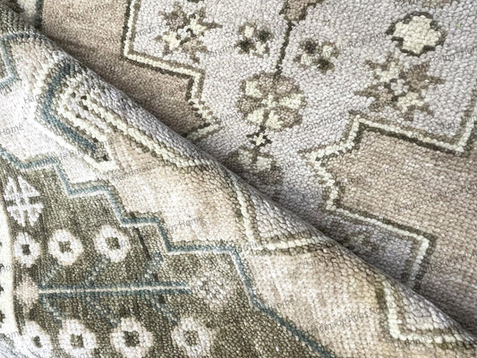 Close-up of the beautiful beige and white knotting detail in the center field of the rug.