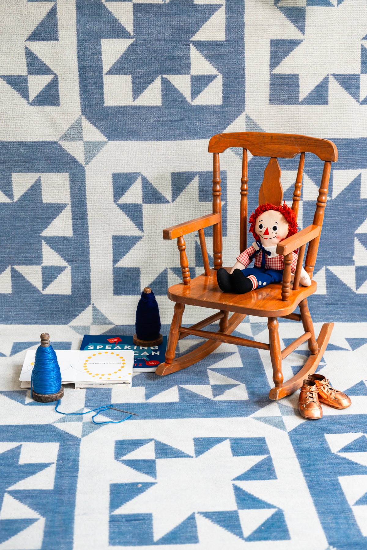 Blue and ivory Modern Oushak geometric star area rug styled with a wooden rocking chair