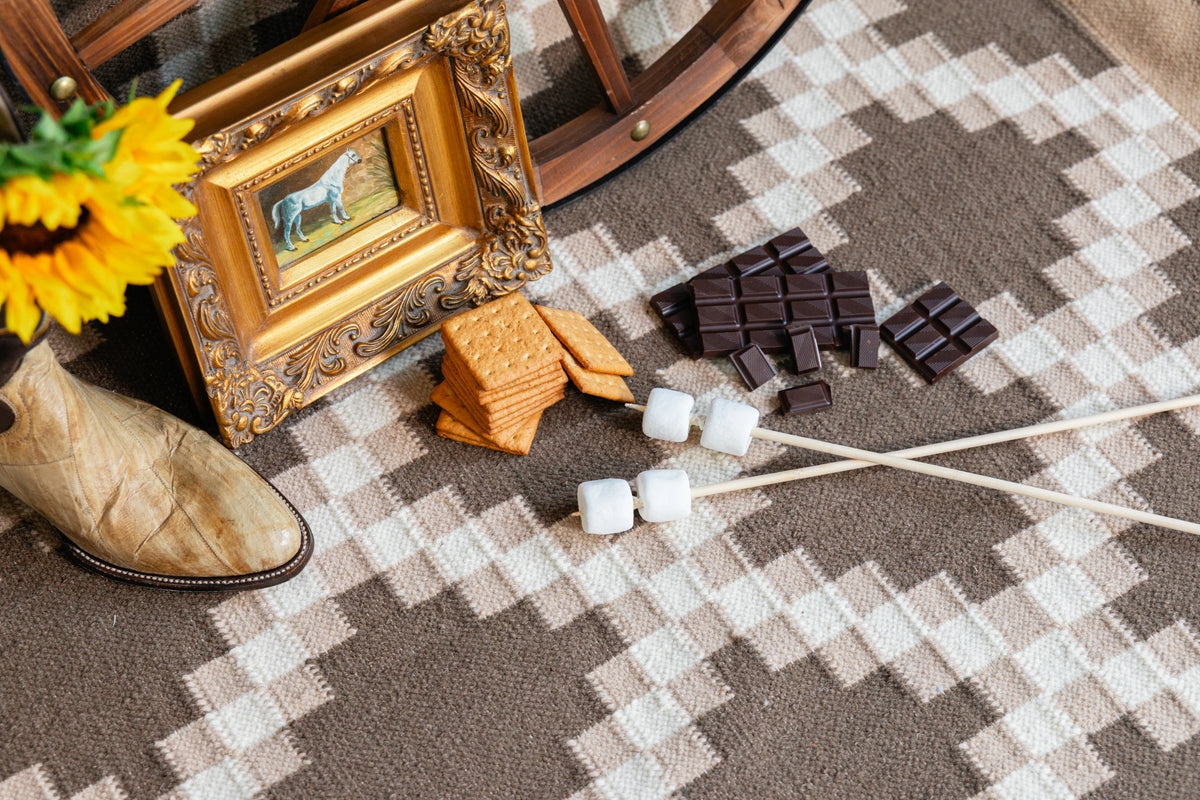 Close-up of brown and ivory flatweave rug showing interlocking stepped geometric pattern