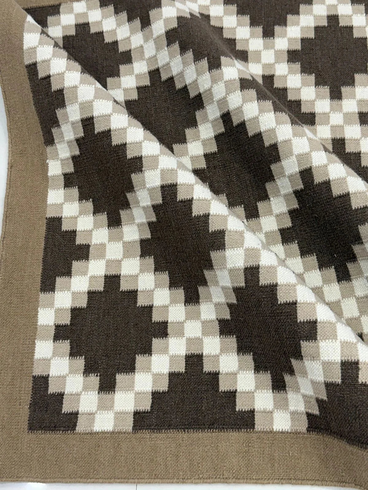 Detailed view of brown and ivory Southwestern geometric flatweave rug showing its woven pattern